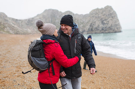 simsearch:6113-07790711,k - Affectionate, happy couple in warm clothing on snowy winter beach Photographie de stock - Premium Libres de Droits, Code: 6124-09188898