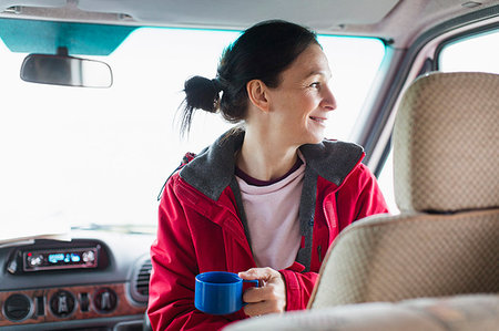 Smiling woman drinking coffee in motor home Stock Photo - Premium Royalty-Free, Code: 6124-09188823