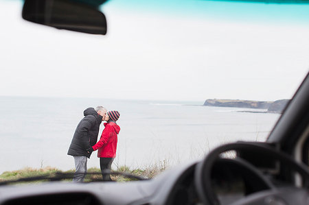 simsearch:6113-07242393,k - Affectionate couple kissing outside motor home on cliff overlooking ocean Stock Photo - Premium Royalty-Free, Code: 6124-09188830