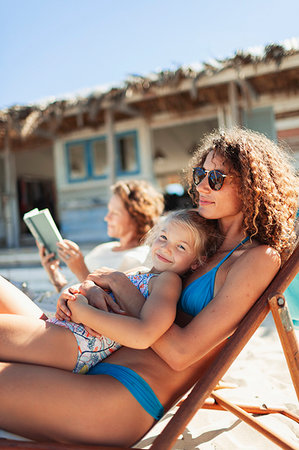 simsearch:6113-06909372,k - Portrait happy daughter relaxing with mother on sunny beach Stock Photo - Premium Royalty-Free, Code: 6124-09269582