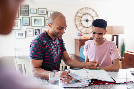 family planning - Father helping teenage son with homework in kitchen Photographie de stock - Premium Libres de Droits, Code: 6124-09269953