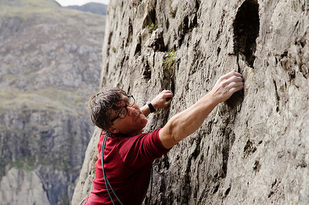 simsearch:6118-09039107,k - Focused male rock climber scaling rock face Stock Photo - Premium Royalty-Free, Code: 6124-09270027