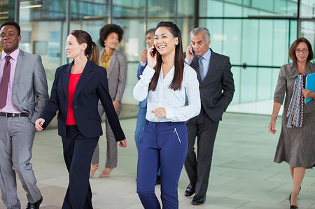 simsearch:649-07520071,k - Smiling businesswoman talking on cell phone and walking Stock Photo - Premium Royalty-Free, Code: 6124-09229140