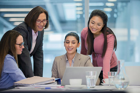 simsearch:614-03507042,k - Smiling businesswomen using laptop in conference room meeting Stock Photo - Premium Royalty-Free, Code: 6124-09229153