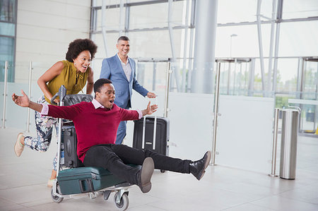 photos of people airport - Playful couple running with luggage cart in airport Stock Photo - Premium Royalty-Free, Code: 6124-09229205