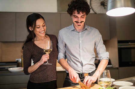 simsearch:6109-08390293,k - Happy couple preparing dinner and drinking white wine in apartment kitchen Stock Photo - Premium Royalty-Free, Code: 6124-09239496