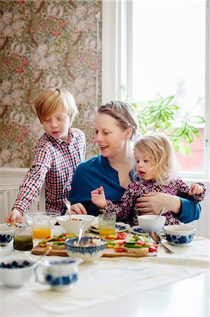 Sweden, Mother with two children (2-3, 10-11) eating breakfast Stock Photo - Premium Royalty-Free, Code: 6126-08643066