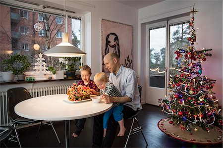 Sweden, Man and two boys (18-23 months, 4-5) decorating gingerbread house Stock Photo - Premium Royalty-Free, Code: 6126-08643202