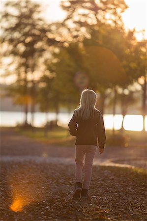 Sweden, Vastergotland, Lerum, Back view of girl (8-9) walking in riverside park Stock Photo - Premium Royalty-Free, Code: 6126-08643840