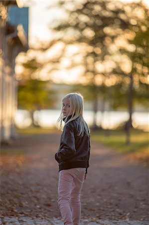 simsearch:6126-08644727,k - Sweden, Vastergotland, Lerum, Portrait of girl (8-9) walking in riverside park, looking over shoulder Stock Photo - Premium Royalty-Free, Code: 6126-08643841