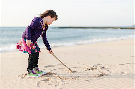 Portugal, Alentejo, Vila Nova de Milfontes, Girl (4-5) drawing on beach sand Stock Photo - Premium Royalty-Free, Code: 6126-08643980