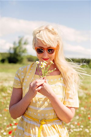 France, Blonde woman with flower in meadow Stock Photo - Premium Royalty-Free, Code: 6126-08644016