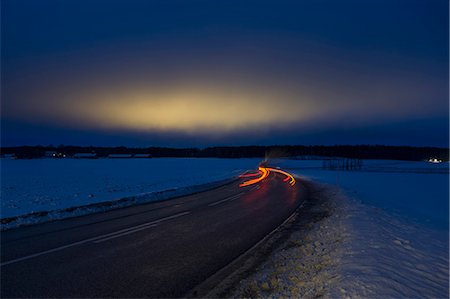 simsearch:6126-08643376,k - Sweden, Sodermanland, Skavsta, Light trail on road in winter at dusk Foto de stock - Sin royalties Premium, Código: 6126-08659075