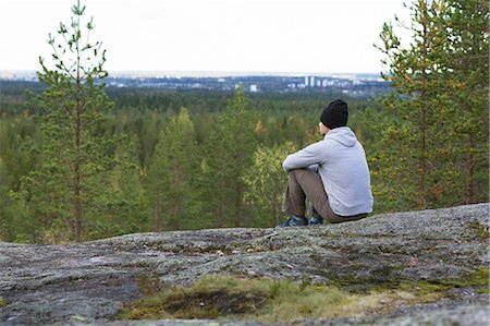 simsearch:6126-08643505,k - Sweden, Vasterbotten, Umea, Mid adult man sitting on rocks looking at view Stock Photo - Premium Royalty-Free, Code: 6126-08659284