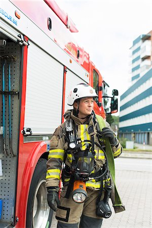 flashing - Sweden, Female firefighter with equipment standing next to fire truck Stock Photo - Premium Royalty-Free, Code: 6126-08635157