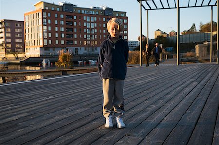 Sweden, Sodermanland, Hammarby Sjostad, Portrait of boy (6-7) standing on pier Fotografie stock - Premium Royalty-Free, Codice: 6126-08635138