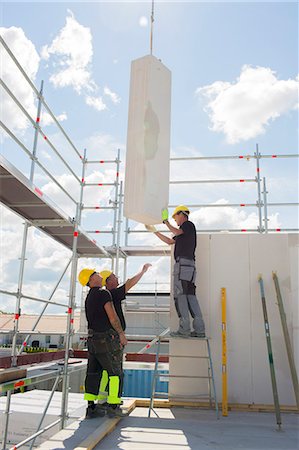 sky clothes - Sweden, Ostergotland, Linkoping, Construction workers preparing building block to be lifted Stock Photo - Premium Royalty-Free, Code: 6126-08635548