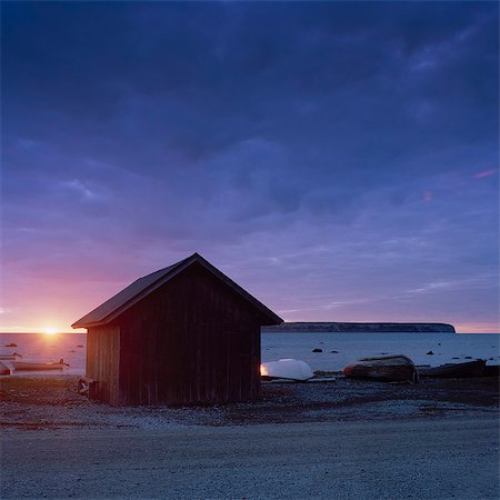 simsearch:6126-08643376,k - Sweden, Gotland, Eksta Coast, Wooden house on seashore at sunset Foto de stock - Sin royalties Premium, Código: 6126-08635782