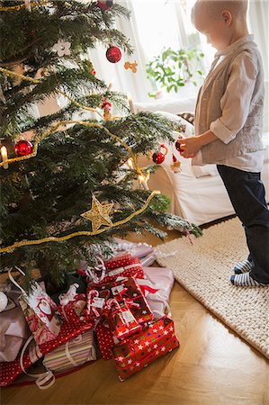 stand infant - Sweden, Little blonde boy (4-5) standing next to Christmas tree Photographie de stock - Premium Libres de Droits, Code: 6126-08635940