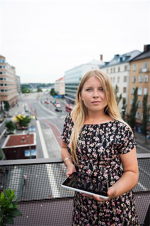 Sweden, Stockholm, Sodermalm, Hornstull, Portrait of woman standing on balcony holding digital tablet Stock Photo - Premium Royalty-Free, Code: 6126-08636092