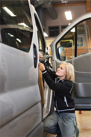 feature - Sweden, Woman working on car at workshop Stock Photo - Premium Royalty-Free, Code: 6126-08636101