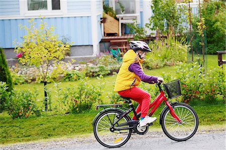 riding bike female basket - Finland, Keski-Suomi, Jyvaskyla, Side view of girl (6-7) riding bicycle next to house Stock Photo - Premium Royalty-Free, Code: 6126-08636526