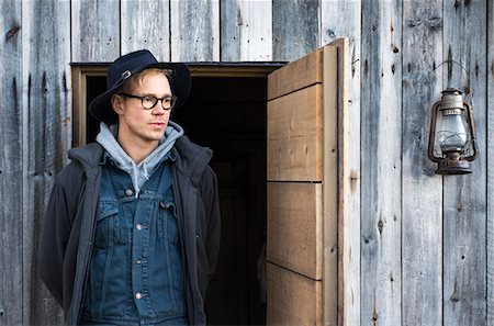 finnish ethnicity - Finland, Pirkanmaa, Ruovesi, Mid adult man in hat standing in front of wooden cottage Stock Photo - Premium Royalty-Free, Code: 6126-08636771