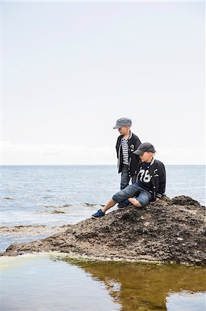 Sweden, Gotland, Boys (6-7, 8-9) on rock in sea Stock Photo - Premium Royalty-Free, Code: 6126-08781178