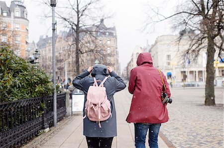 Sweden, Stockholm, Young couple walking through city in falling snow Stock Photo - Premium Royalty-Free, Code: 6126-08781248