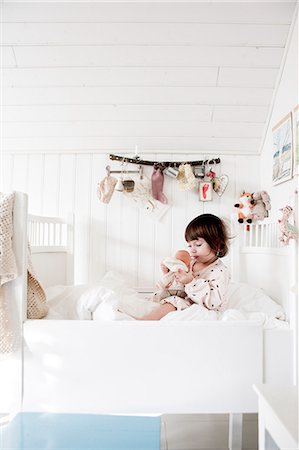 redhead baby girl - Sweden, Small girl (2-3) sitting in bed and embracing doll Stock Photo - Premium Royalty-Free, Code: 6126-08781206