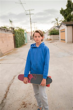 Portrait of boy holding skateboard in San Diego Stock Photo - Premium Royalty-Free, Code: 6126-09103013