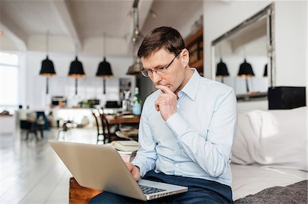 Man using computer with concentration Stock Photo - Premium Royalty-Free, Code: 6126-09103568