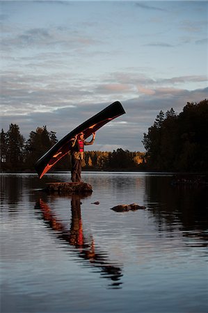 simsearch:6126-08643505,k - Mature man standing on rock in lake and holding boat Stock Photo - Premium Royalty-Free, Code: 6126-09103751