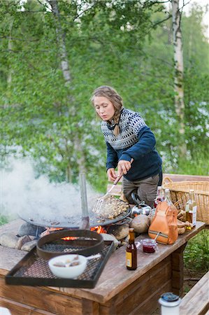 suéters - A woman cooking on a fire pit Foto de stock - Sin royalties Premium, Código: 6126-09103829