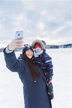 simsearch:6108-06167383,k - Mother taking selfie with son in snow Stock Photo - Premium Royalty-Free, Code: 6126-09103934