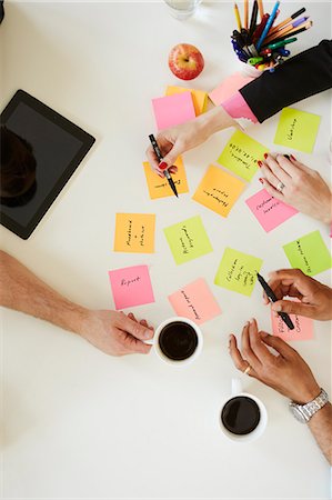 People writing notes and holding mug on desk Foto de stock - Sin royalties Premium, Código: 6126-09104262