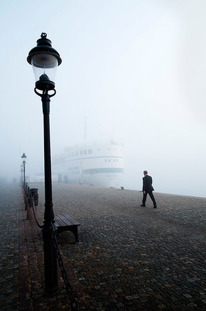 simsearch:6126-08643505,k - Man walking on foggy day in Stockholm Stock Photo - Premium Royalty-Free, Code: 6126-09266501
