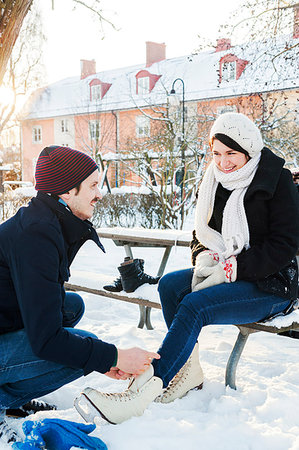 Man lacing woman's ice skates in Enskede, Sweden Stock Photo - Premium Royalty-Free, Code: 6126-09204337