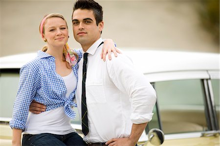 Couple standing next to car smiling at the camera Stock Photo - Premium Royalty-Free, Code: 6128-08747626