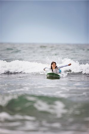 sea woman - Young woman surfing at the beach. Stock Photo - Premium Royalty-Free, Code: 6128-08747817