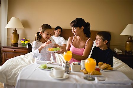 family, hotel - Family enjoying breakfast in bed in hotel room. Stock Photo - Premium Royalty-Free, Code: 6128-08766549