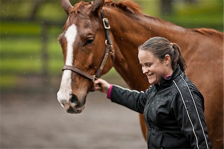 Smiling young horse training leader her horse by it's bridle. Foto de stock - Sin royalties Premium, Código: 6128-08766741