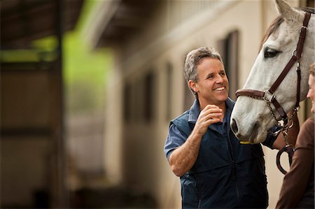 Two horse handlers checking and making preparations for their horse. Foto de stock - Sin royalties Premium, Código: 6128-08766762