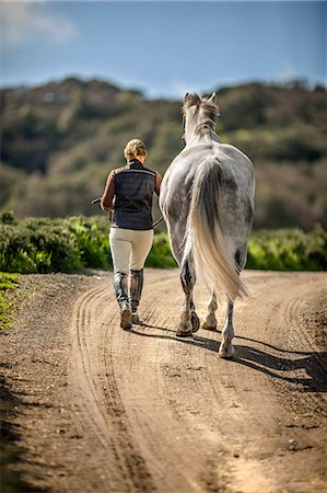 riding boots not equestrian not cowboy not child - Woman leading her horse on a rural path. Stock Photo - Premium Royalty-Free, Code: 6128-08766770