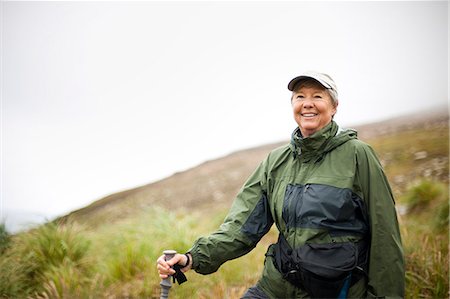 sports and hiking - Woman smiles as she stops to admire the scenery on a hike. Stock Photo - Premium Royalty-Free, Code: 6128-08766827