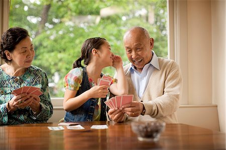 Senior couple playing cards with their granddaughter. Stock Photo - Premium Royalty-Free, Code: 6128-08767028