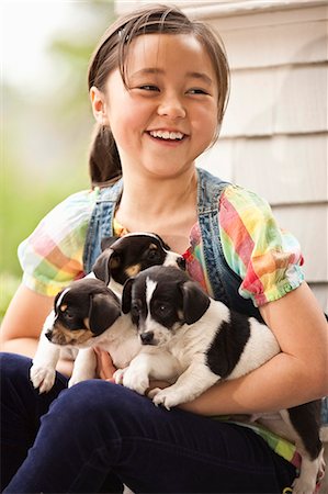 frisky puppy - Girl holding three puppies. Stock Photo - Premium Royalty-Free, Code: 6128-08767039