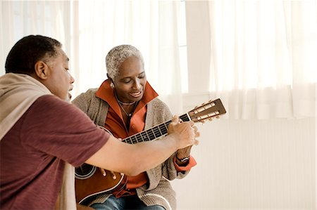 elderly african american male - Happy senior man teaching his wife how to play guitar. Stock Photo - Premium Royalty-Free, Code: 6128-08767258