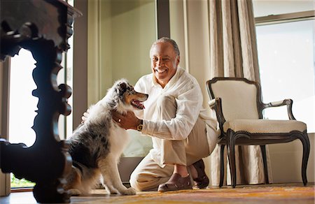 den - Portrait of a smiling mature man petting his dog. Stock Photo - Premium Royalty-Free, Code: 6128-08767205