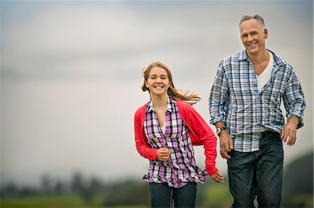 Portrait of a smiling father and daughter running side by side. Foto de stock - Sin royalties Premium, Código: 6128-08767302